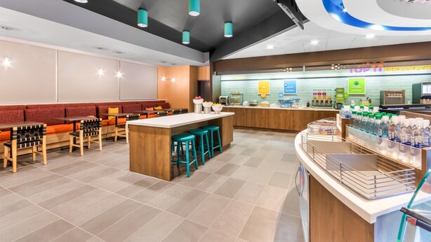 A modern restaurant with a central island, bar stools, and a counter with water bottles. - Tru By Hilton Pensacola I-10 North Davis Highway (Pensacola)