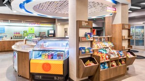A modern food court with a refrigerated display, snack bar, and local items section. - Tru By Hilton Pensacola I-10 North Davis Highway (Pensacola)
