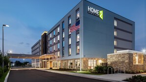 Un moderno edificio de hotel con un cartel que dice "HOME 2 SUITES BY HILTON".