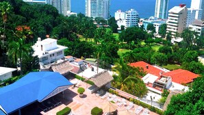 A resort with a pool area, a thatched-roof structure, and a view of the ocean. - Cozy Condo in Acapulco – Perfect for Long Stays & Work Trips (Acapulco de Juárez)