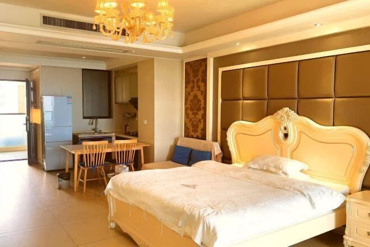 Ein Schlafzimmer mit einem großen Bett, einem Esstisch und einer Küchenzeile.
