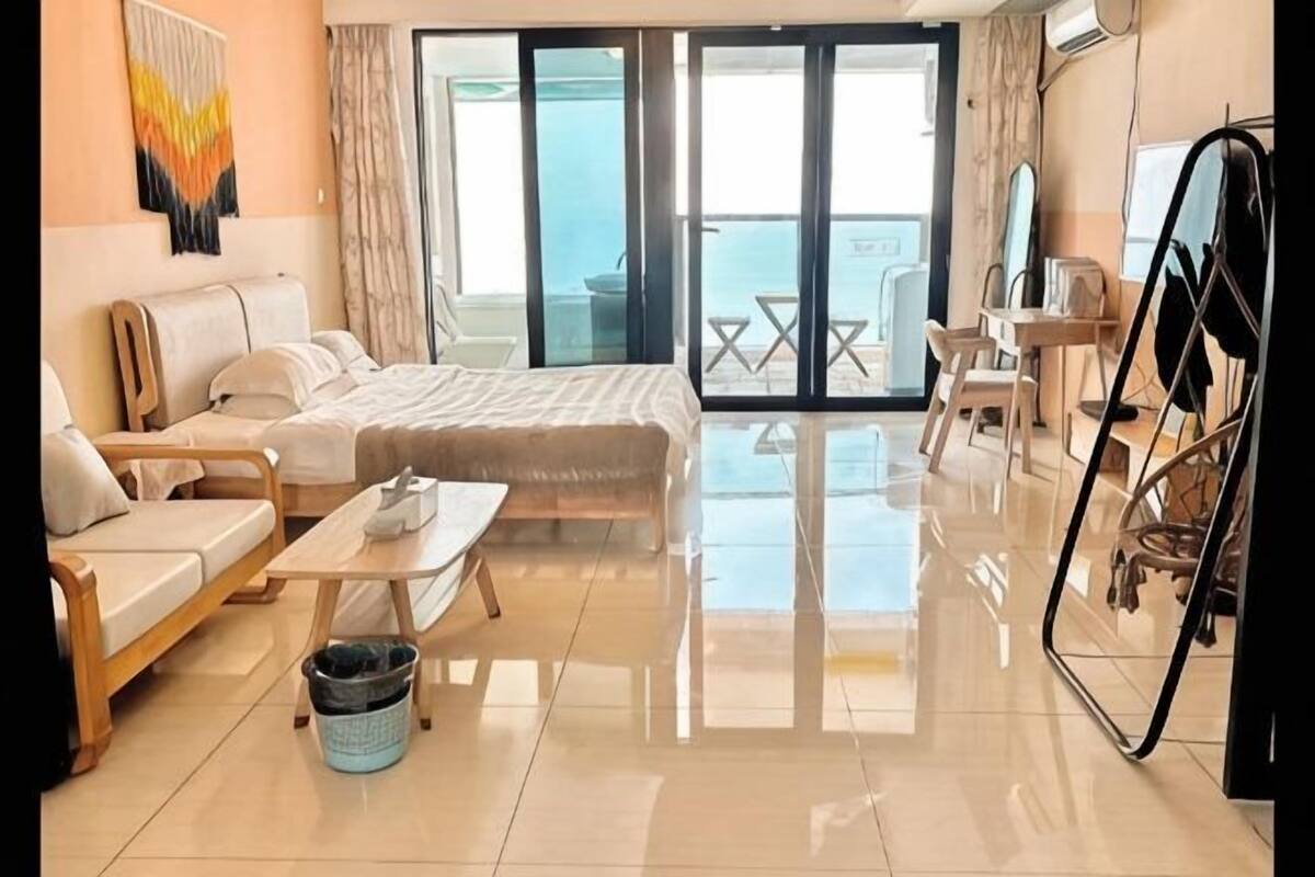 Ein modernes Hotelzimmer mit Bett, Sofa und Esstisch.
