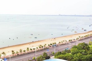 Une vue sur la côte, avec une plage, des palmiers et une route.