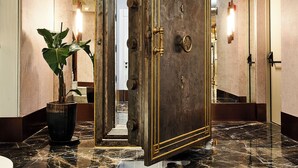 A hallway with a large, ornate door, a potted plant, and a marble floor. - Les Temps Istanbul Karakoy, Curio Collection By Hilton (Istanbul)