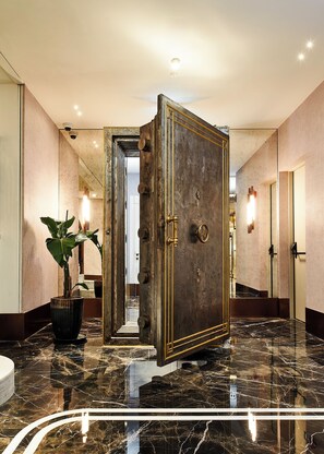 A hallway with a large, ornate door, a potted plant, and a marble floor. - Les Temps Istanbul Karakoy, Curio Collection By Hilton (Istanbul)