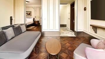 Ein Hotelzimmer mit einer Couch, einem kleinen runden Tisch und einem gemusterten Boden.
