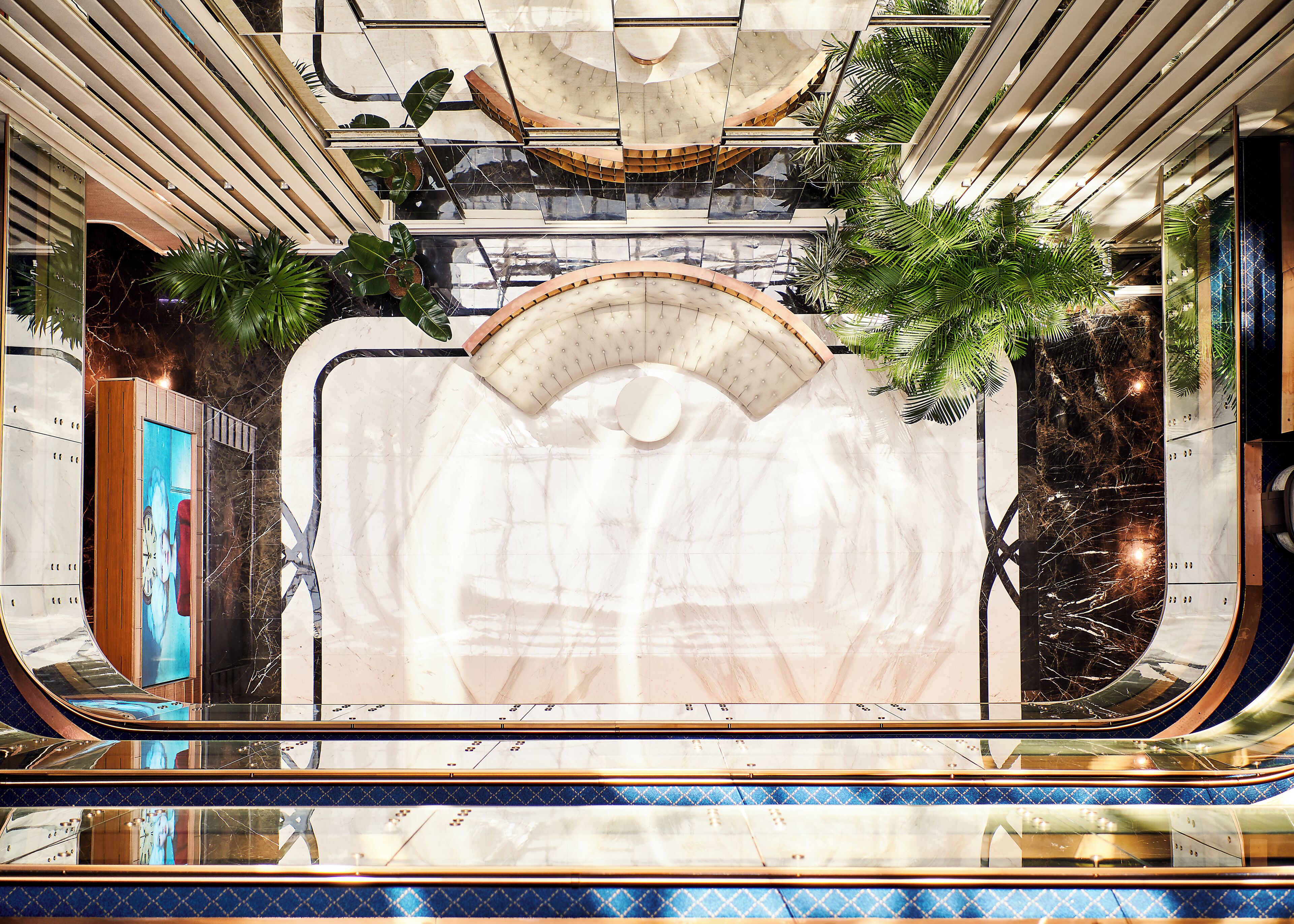 Un interior moderno con una zona de estar central, superficies reflectantes y plantas.