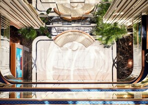 A modern interior with a central seating area, reflective surfaces, and greenery. - Les Temps Istanbul Karakoy, Curio Collection By Hilton (Istanbul)