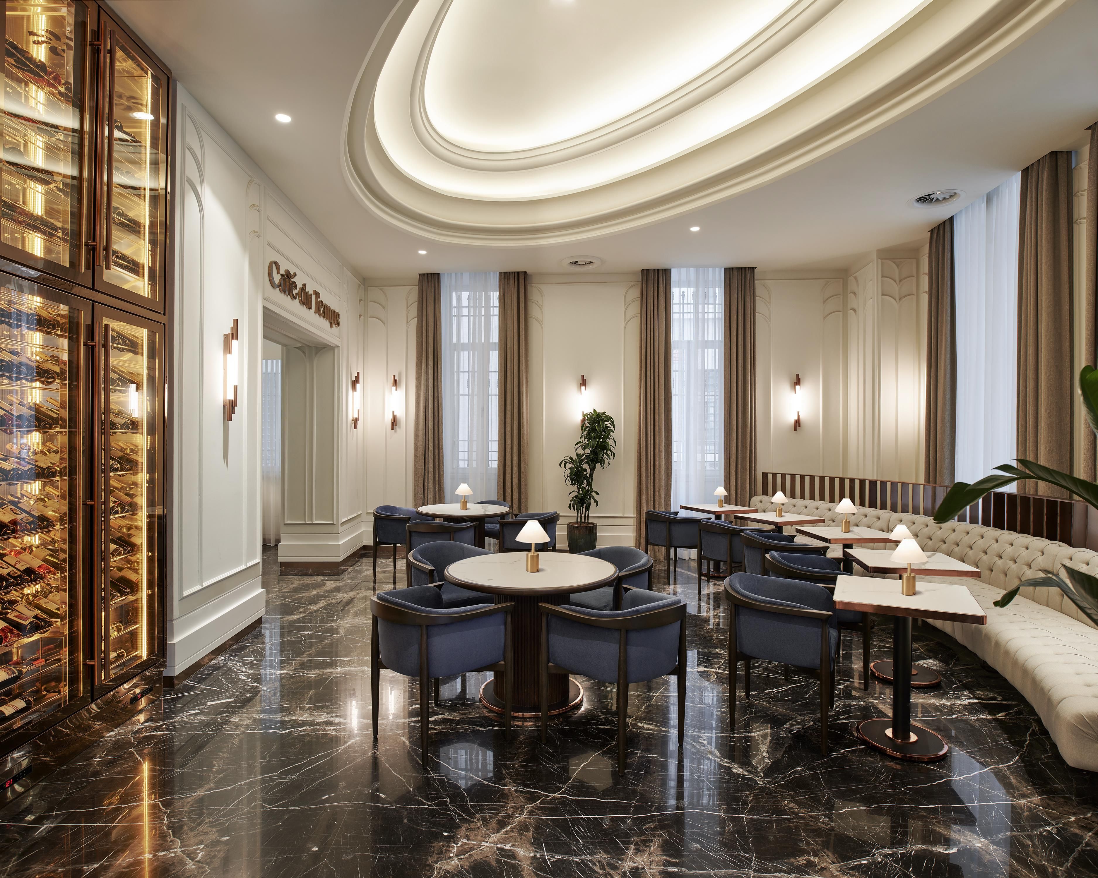 Un elegante vestíbulo de hotel con suelos de mármol, asientos refinados y una bodega de vinos.