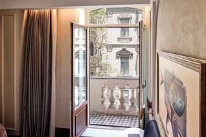 A room with a view of a courtyard, a door leading outside, and a framed artwork on the wall. - Les Temps Istanbul Karakoy, Curio Collection By Hilton (Istanbul)