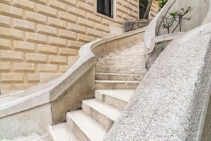 A stone staircase with a curved handrail leading to a door with a window. - Les Temps Istanbul Karakoy, Curio Collection By Hilton (Istanbul)