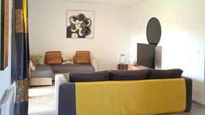 A modern living room with a sofa, a coffee table, and a flat-screen TV.