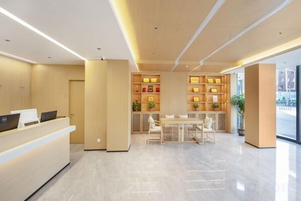 A modern reception area with a reception desk, seating area, and a plant.