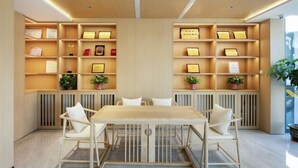 A modern interior with a wooden table and chairs, shelves with certificates, and potted plants. - GreenTree Inn (Fengtai Beijing Dongda Street) (Beijing)