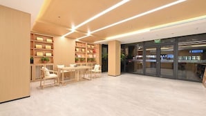 A modern interior with a reception desk, seating area, and a glass storefront. - GreenTree Inn (Fengtai Beijing Dongda Street) (Beijing)