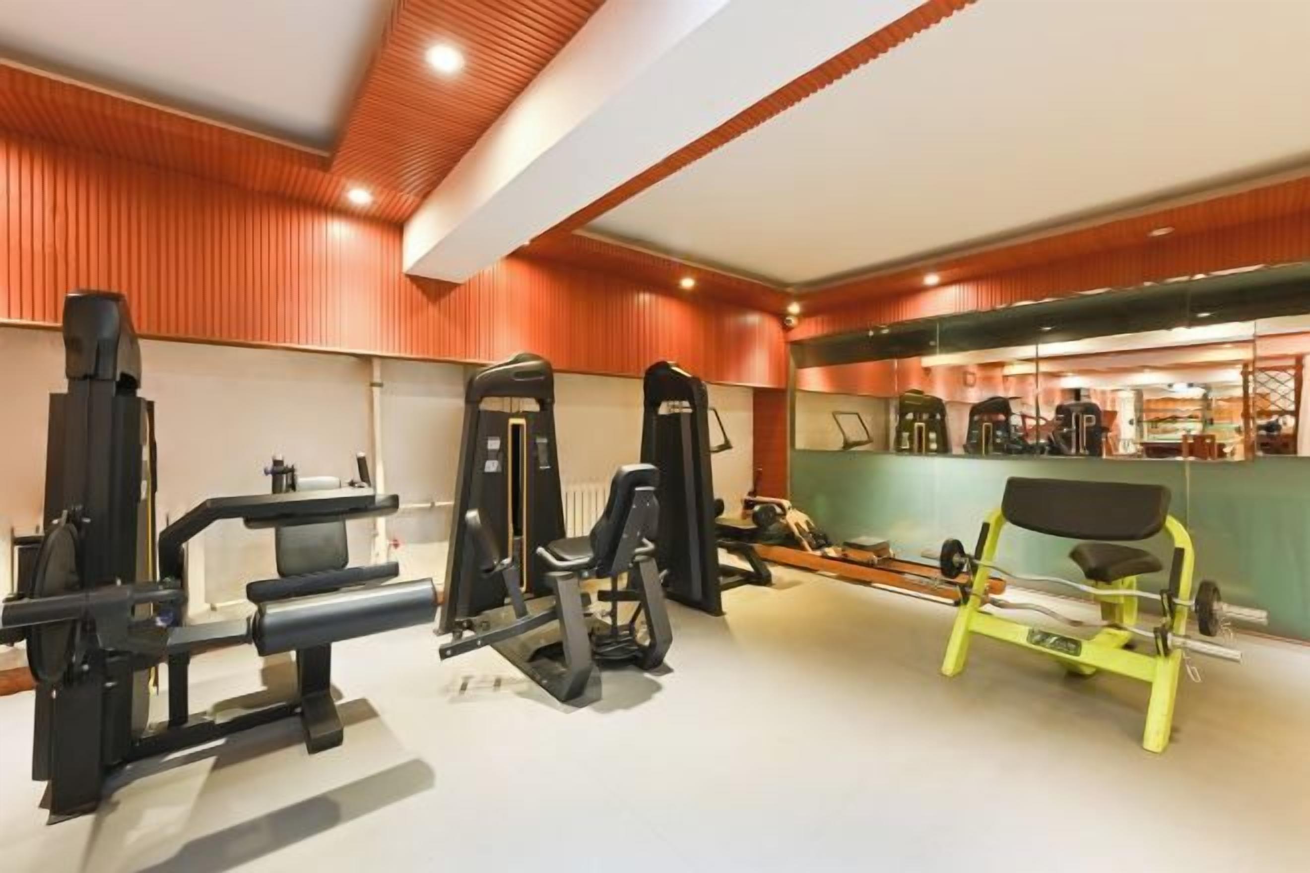 A gym with various exercise machines, including a bench press and a squat rack.
