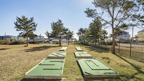 Un parcours de golf doté de plusieurs greens d’entraînement et entouré d’une clôture.
