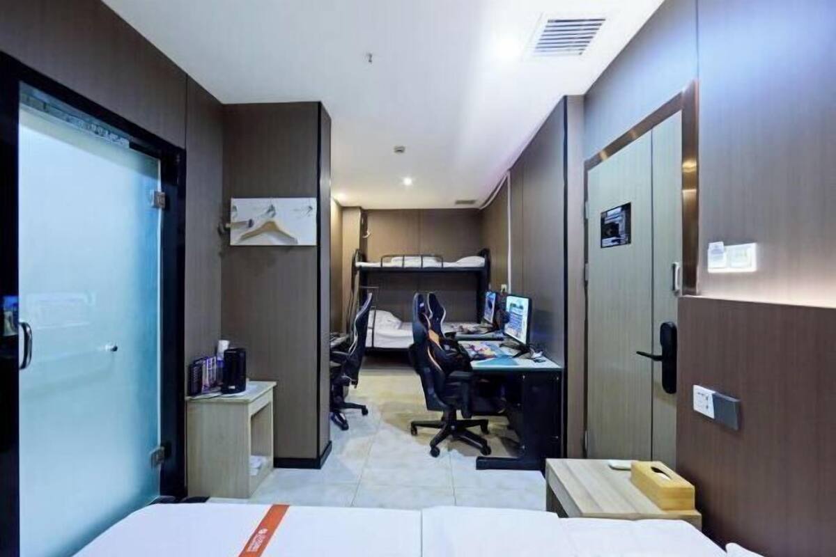 Une chambre d’hôtel équipée d’un lit, d’un bureau, d’un ordinateur et d’une armoire.