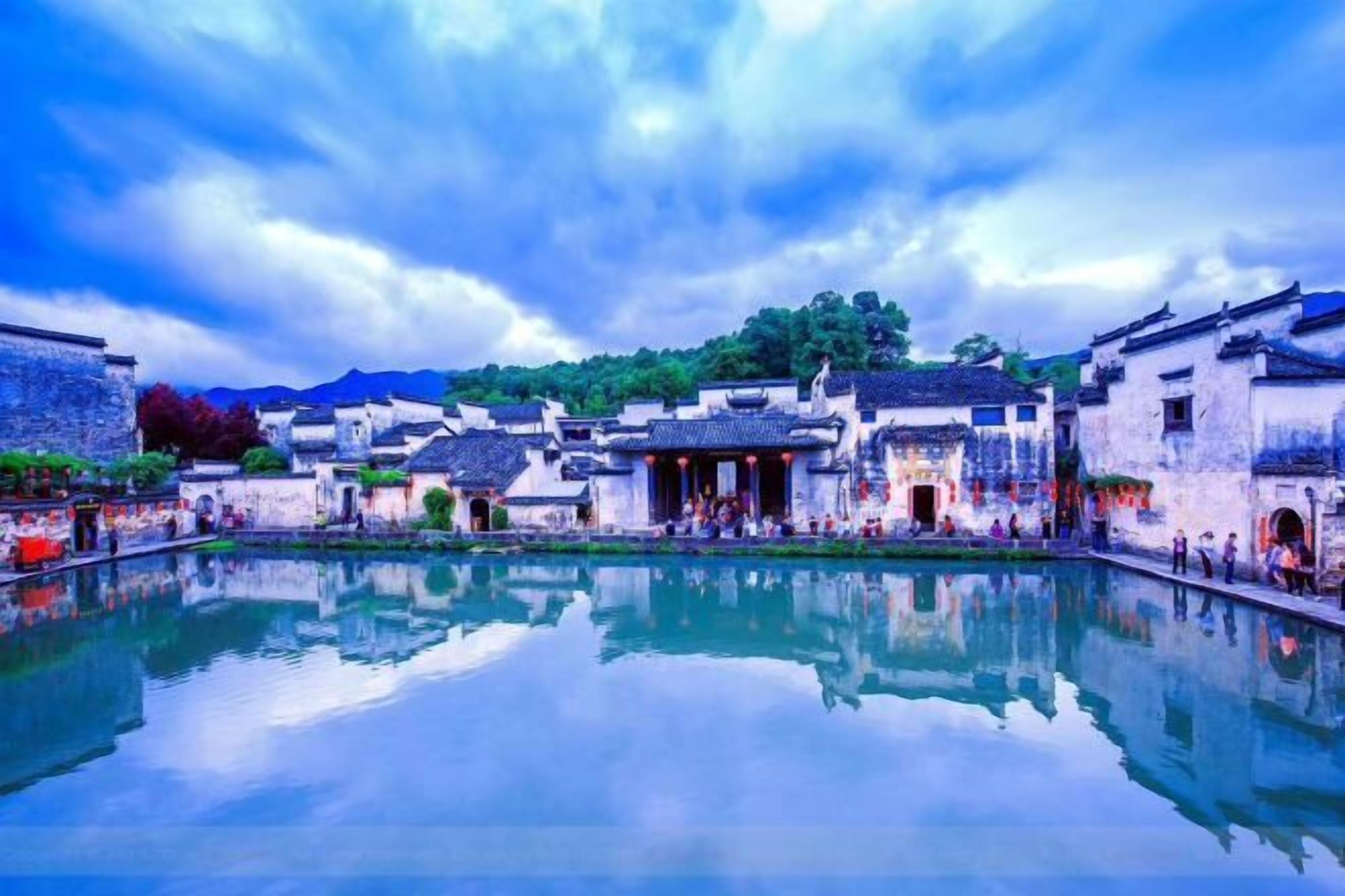 A traditional courtyard with buildings, a reflective water feature, and a statue.