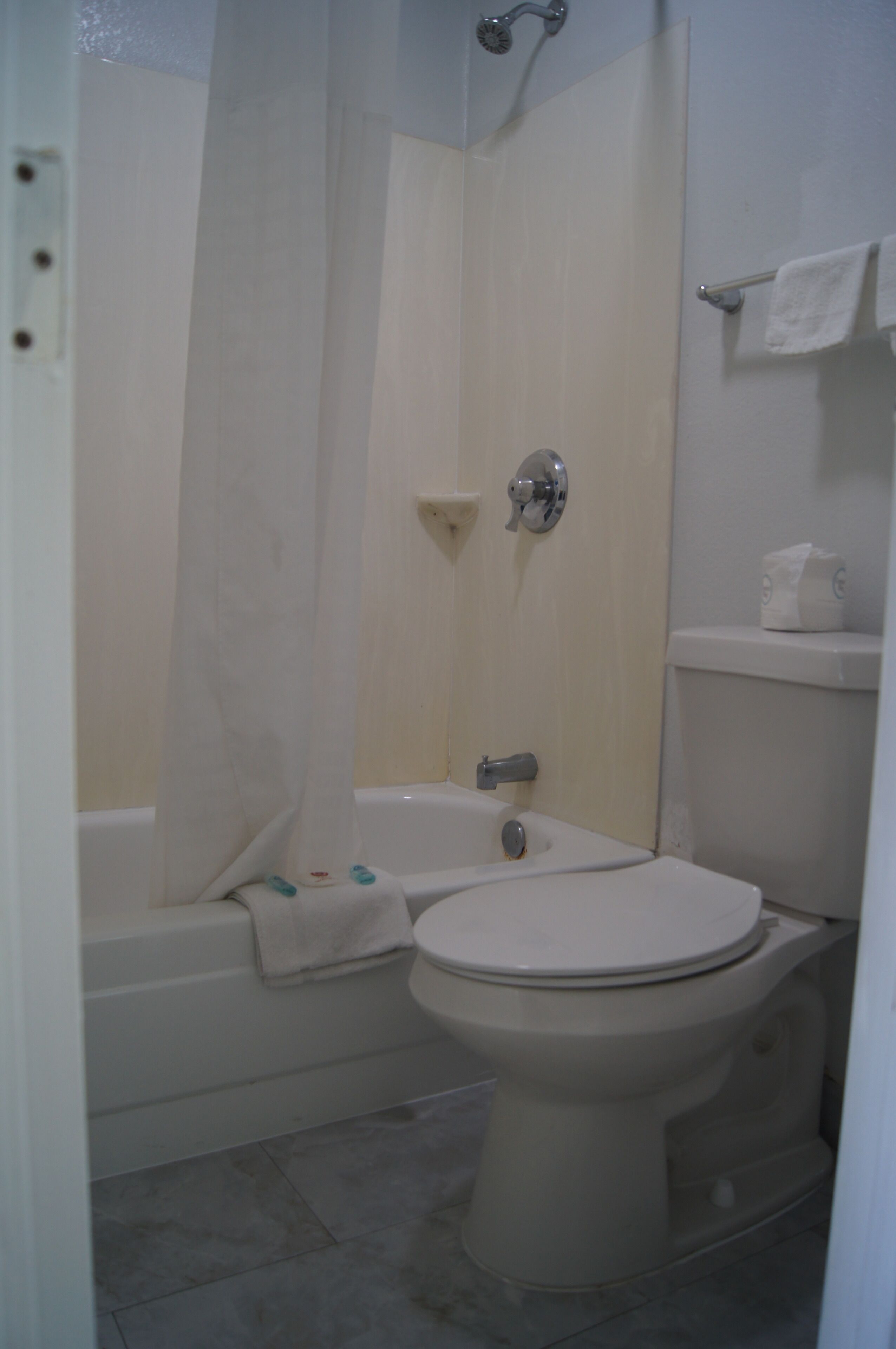 A bathroom with a bathtub, toilet, and shower curtain.