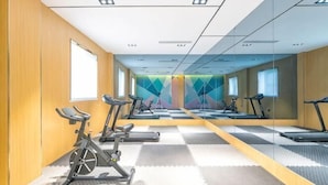 A gym with exercise equipment, mirrors, and a checkered floor.