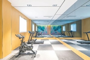 A gym with exercise equipment, mirrors, and a checkered floor. - 7Days Inn Chain Hotel (Beijing Huairou) (Beijing)