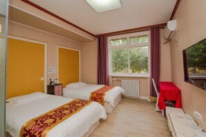 A hotel room with two beds, a small table with a red tablecloth, a window with curtains, and a radiator. - Shijiazhuang Junting Express Hotel (Shijiazhuang)