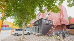 A hotel with a red facade, a staircase leading to the entrance, and a parked car and motorcycles in the foreground. - Shijiazhuang Junting Express Hotel (Shijiazhuang)