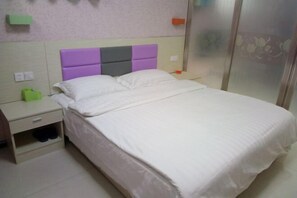 A bed with a headboard, a nightstand, a drawer, and a pair of shoes. - Garden Hotel (Sankong Scenic Spot) (Qufu)