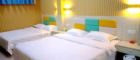 A hotel room with two beds, a nightstand, a trash bin, and a wall with vertical blinds.
