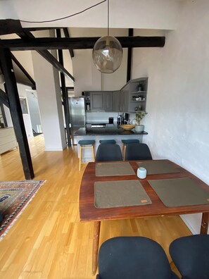 Enjoy meals in the spacious dining area with a wooden table and chairs.