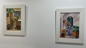 Deux tableaux encadrés représentant des scènes d’intérieur avec des escaliers et des plantes en pot.
