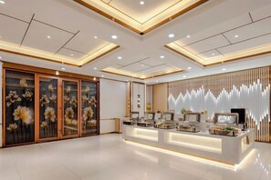 A modern reception area with a central counter, decorative panels, and a ceiling with recessed lighting. - Taiyuan Furong Hotel (Taiyuan)