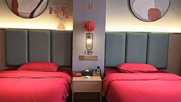 Una habitación de hotel con dos camas, una mesita de noche, una lámpara y una obra de arte colgada en la pared.