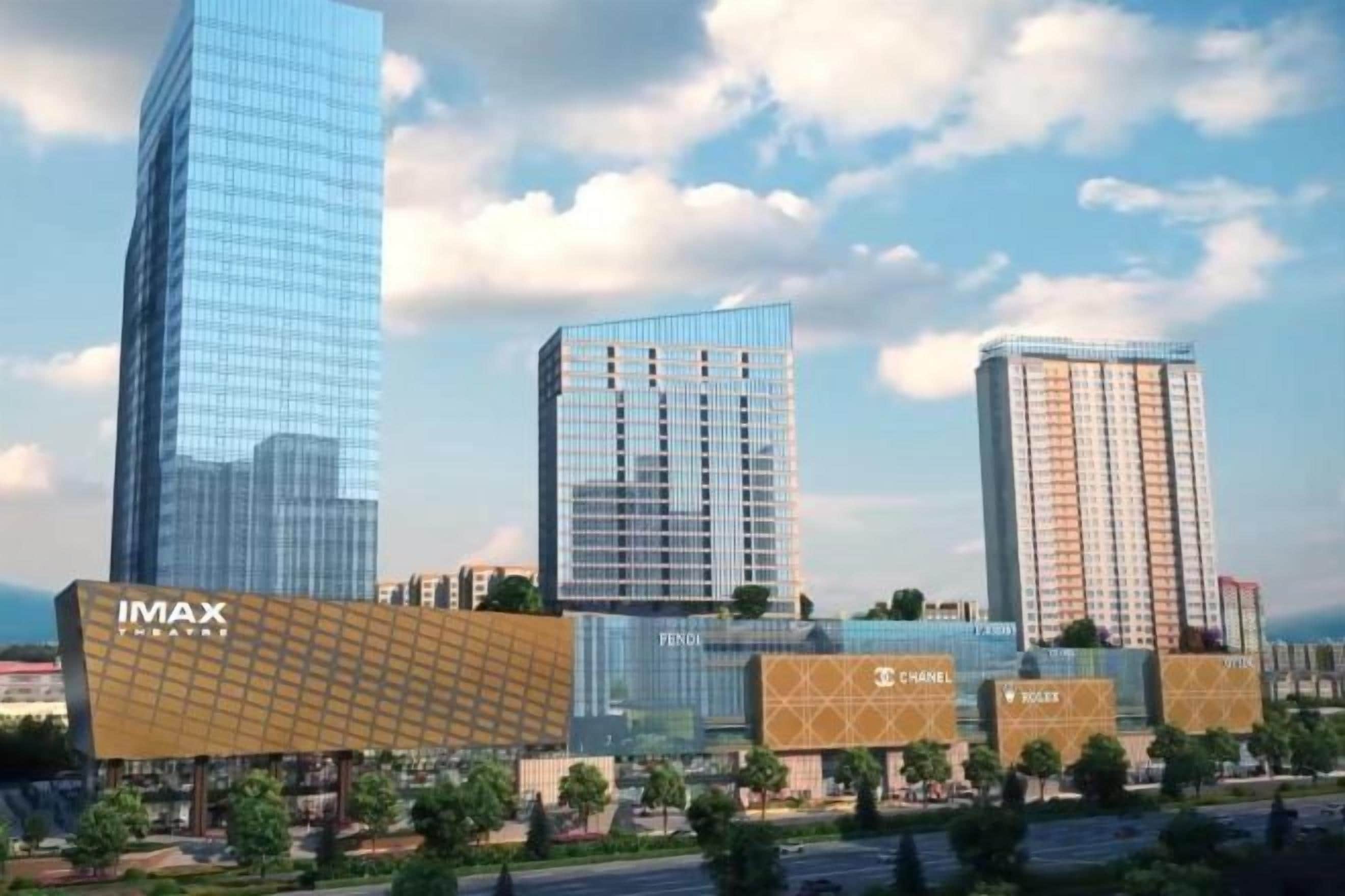 A modern urban skyline with high-rise buildings, including a prominent IMAX cinema.