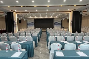 A conference room with rows of tables and chairs, a large screen at the front, and a stage area. - Taiyuan Furong Hotel (Taiyuan)