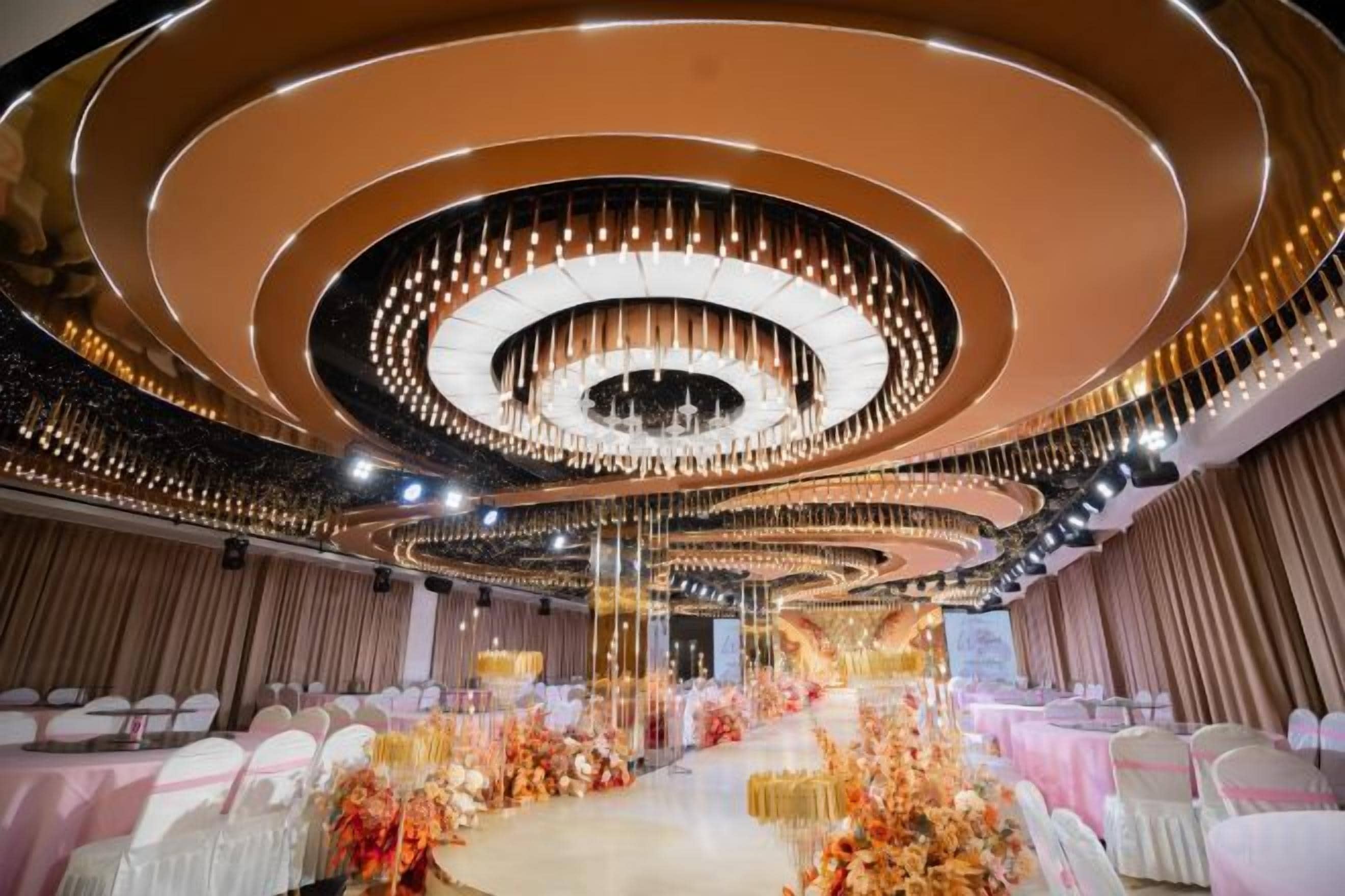 Une salle de banquet dotée d’une scène circulaire, de gradins et d’un plafond décoratif.