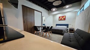 Un dormitorio moderno con cama, escritorio y sofá.