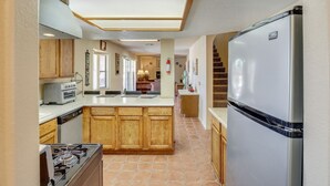 A kitchen with a central island, a stove, a refrigerator, and wooden cabinets. - Best Pet Friendly Home In Bullhead City (Bullhead City)