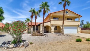 A two-story house with a red-tiled roof, a garage, and palm trees. - Best Pet Friendly Home In Bullhead City (Bullhead City)