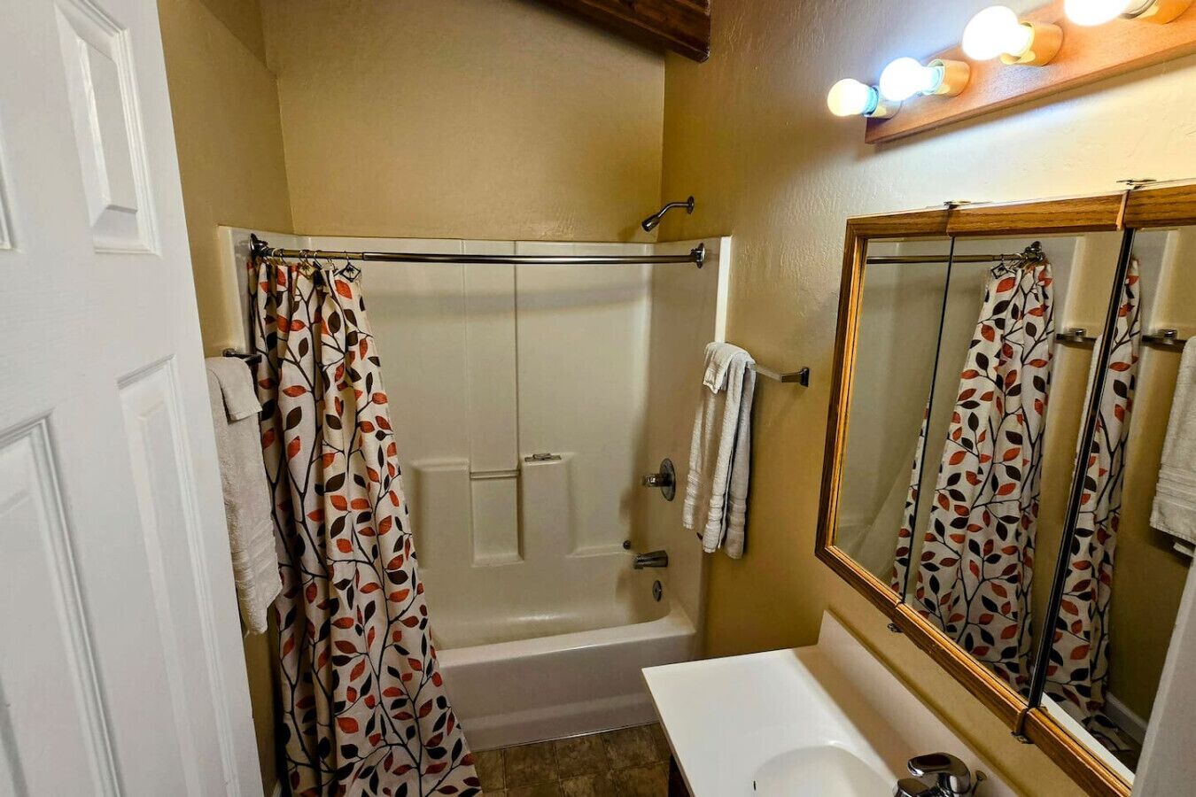 A bathroom with a bathtub, a sink, and a mirror.