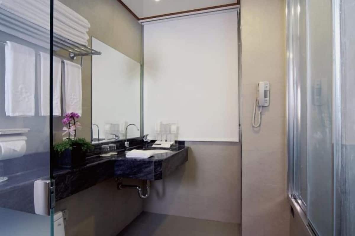 Un baño moderno con cabina de ducha de vidrio, tocador doble y espejo.