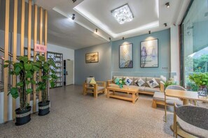A modern interior with a reception desk, seating area, and potted plants. - Yangshuo Liyin Homestay (Yangshuo)