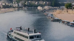 En flod med både og en færge ved kaj.