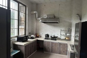 A kitchen with a window, a stove, and a sink. - Yangshuo Liyin Homestay (Yangshuo)