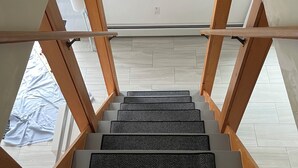 A staircase with wooden railings and a view of the sky through a skylight. - Charming 3-bedroom waterfront cottage in Tremont with spectacular sunsets. (Tremont)