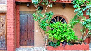 Un edificio tradicional con una puerta de madera y una ventana con un arco decorativo.