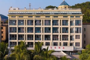 Un edificio de varios pisos con techo plano, ventanas grandes y un letrero con caracteres chinos.