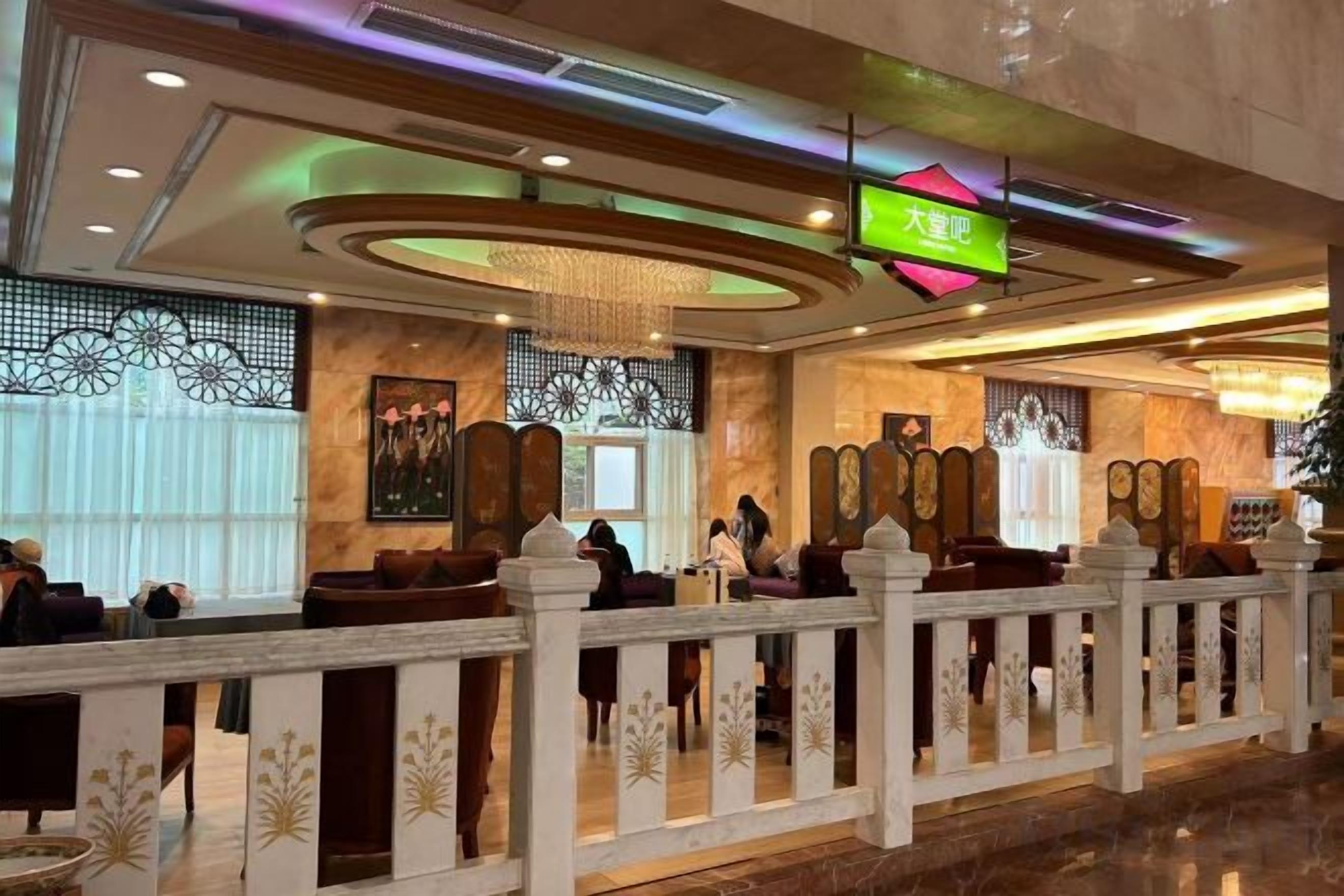 A hotel lobby with a reception desk, seating area, and decorative elements.