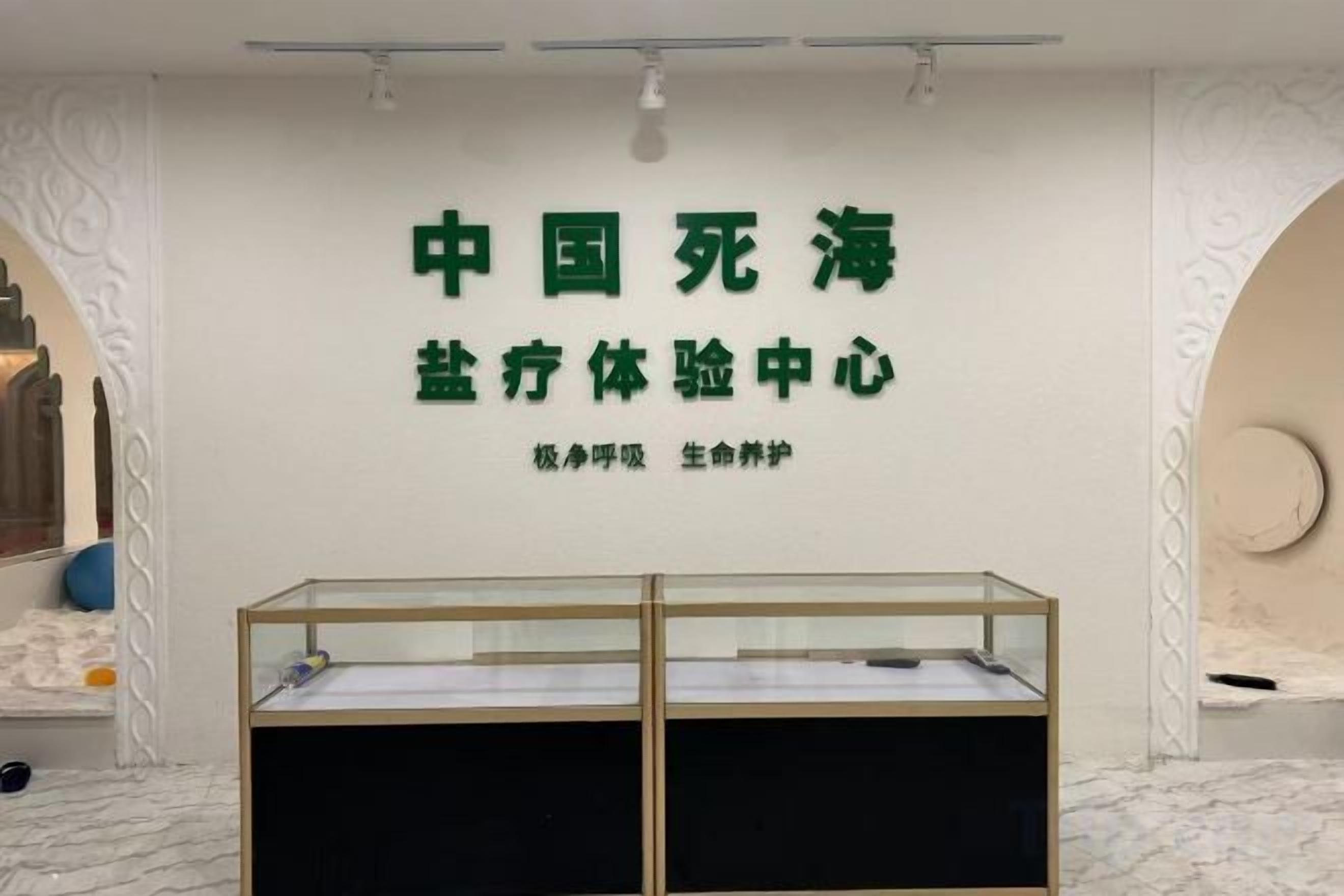 Una habitación con un cartel que dice 'Centro de Experiencia Integral del Mar de la Muerte de China' y una vitrina de vidrio.